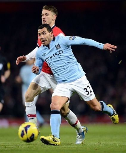 Arsenal's Aaron Ramsey (back) vies with City's Carlos Tevez (R) in London on January 13, 2013